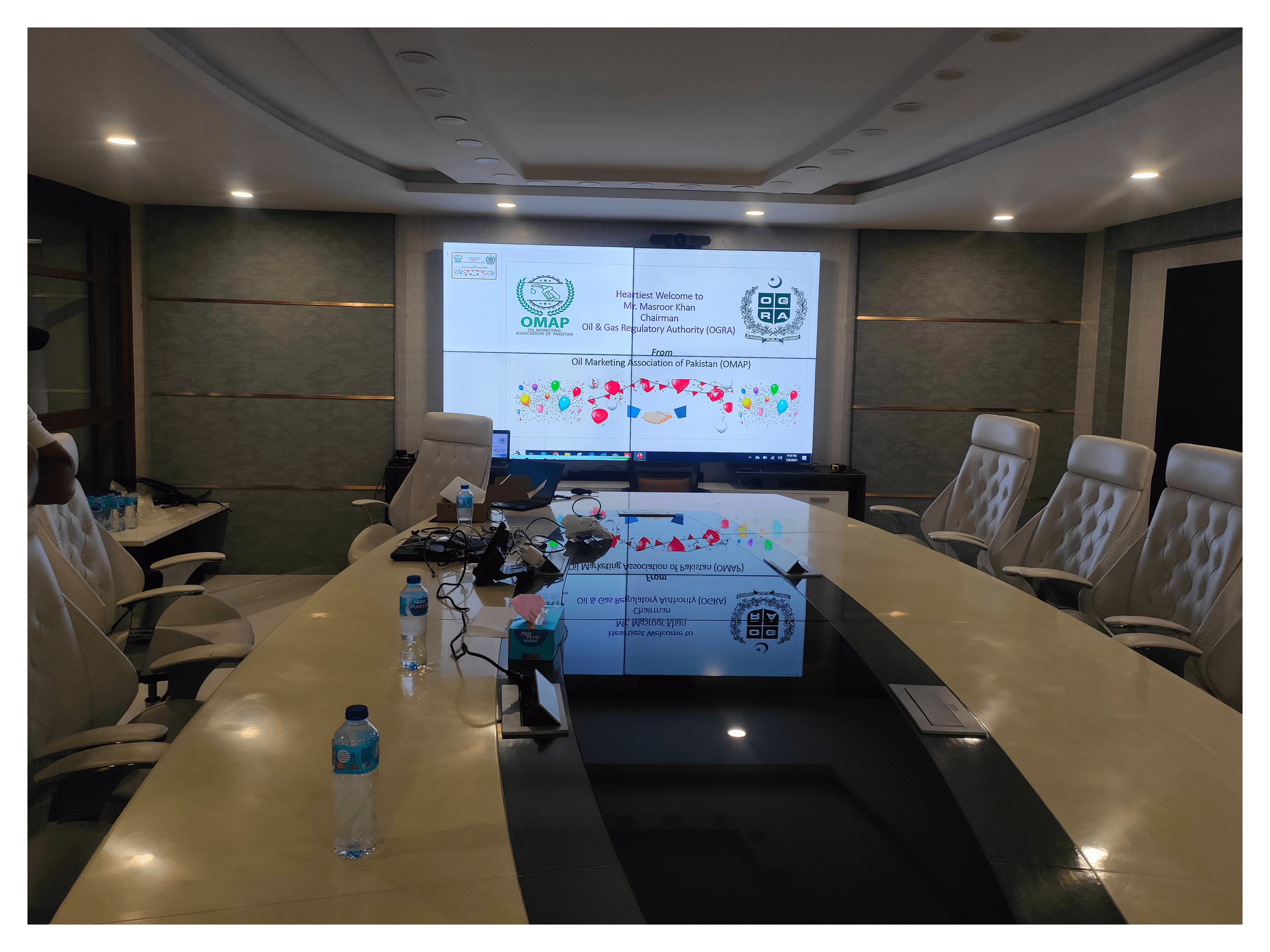 A Big LCD Video Wall Display in a meeting room along with large table and multiple chairs. Video Wall solution setup by EziSol in Lahore.