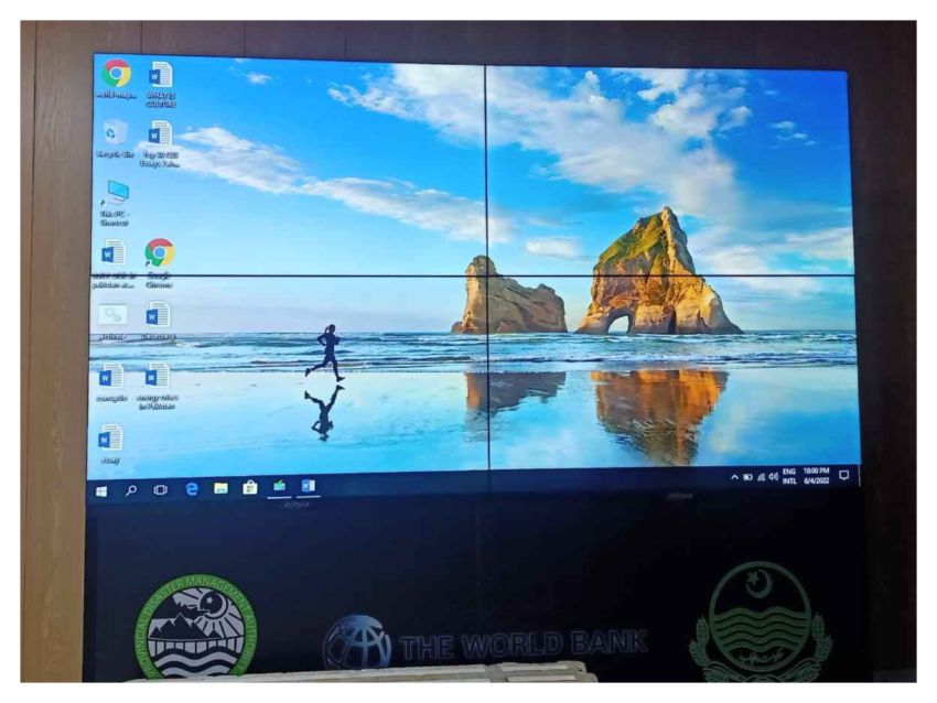 LCD video wall, with an image of a person running on a beach as the wallpaper, icons arranged on the left, and a taskbar at the bottom, Installed by EziSol.