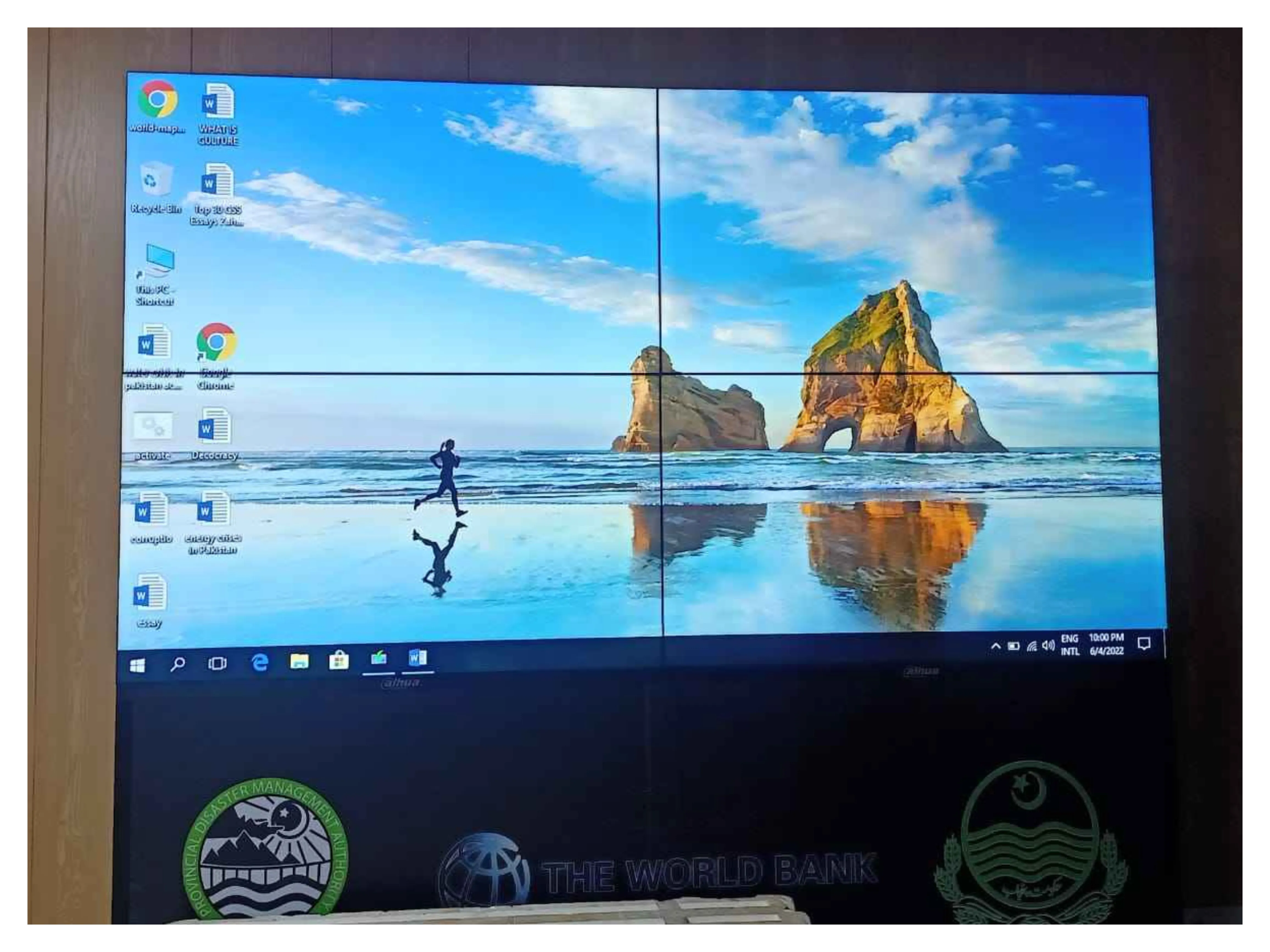 LCD video wall, with an image of a person running on a beach as the wallpaper, icons arranged on the left, and a taskbar at the bottom, Installed by EziSol.